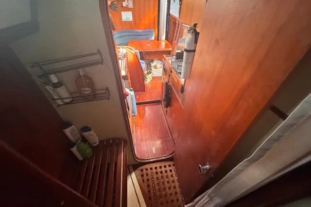 Slide: The Image of Interior view of 1989 Hylas 44 sailboat, featuring wooden cabinetry and cozy seating area. - 62