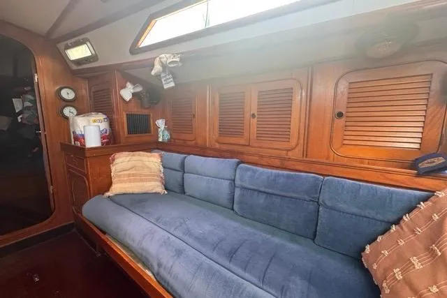 Slide: The Image of 1989 Hylas 44 yacht interior with blue sofa and wooden cabinets. - 66