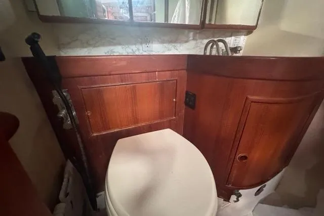 Slide: The Image of 1989 Hylas 44 yacht bathroom with wooden cabinetry and white toilet. - 75