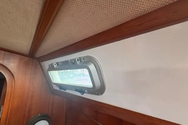 Slide: The Image of Interior of 1989 Hylas 44 sailboat with wooden paneling and porthole window. - 79