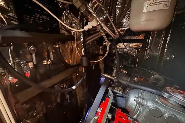 Slide: The Image of Engine room of a 1989 Hylas 44 yacht, showcasing mechanical components and wiring. - 91