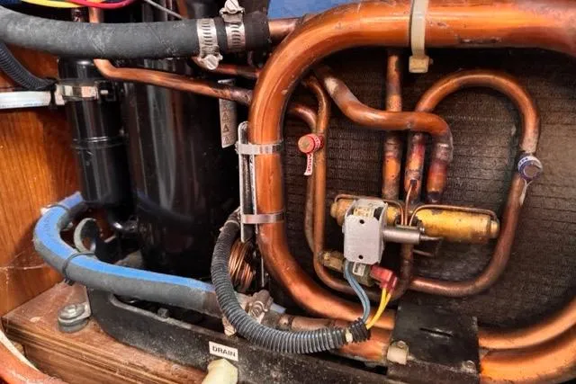 Slide: The Image of 1989 Hylas 44 engine compartment with copper piping and mechanical components. - 98