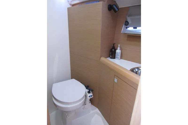 Slide: The Image of 2021 Jeanneau Sun Odyssey 349 yacht bathroom with modern fixtures and wooden cabinetry. - 17