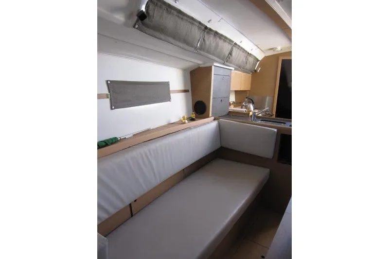 Slide: The Image of Interior of 2021 Jeanneau Sun Odyssey 349 sailboat, featuring a cozy seating area and kitchenette. - 2