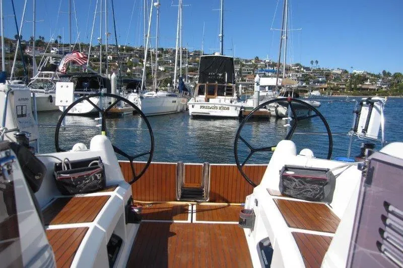 Slide: The Image of 2021 Jeanneau Sun Odyssey 349 sailboat cockpit with dual steering wheels in a marina. - 31