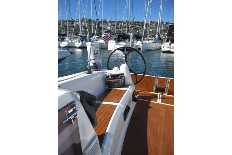 Slide: The Image of 2021 Jeanneau Sun Odyssey 349 sailboat cockpit with wooden deck, docked in marina. - 32