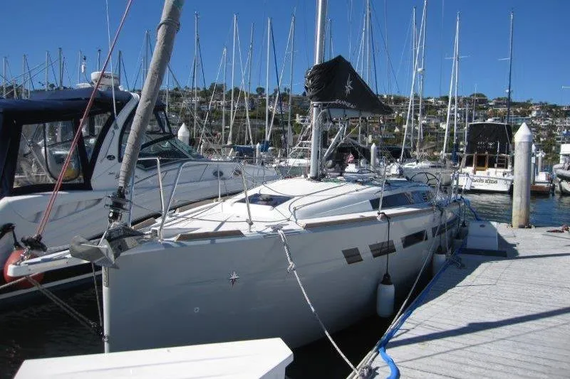 Slide: The Image of 2021 Jeanneau Sun Odyssey 349 sailboat docked at a marina with clear blue skies. - 40