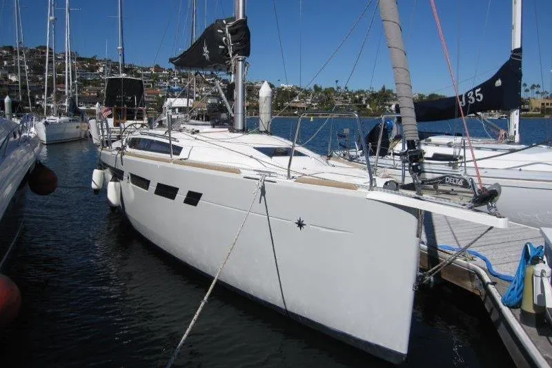 Slide: The Image of 2021 Jeanneau Sun Odyssey 349 sailboat docked in a marina under clear blue skies. - 41