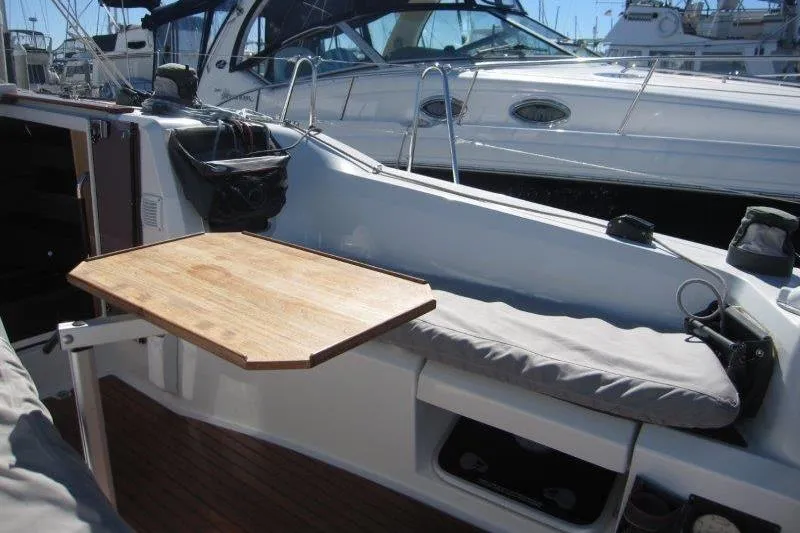 Slide: The Image of Cockpit of 2021 Jeanneau Sun Odyssey 349 with wooden table and cushioned seating. - 46