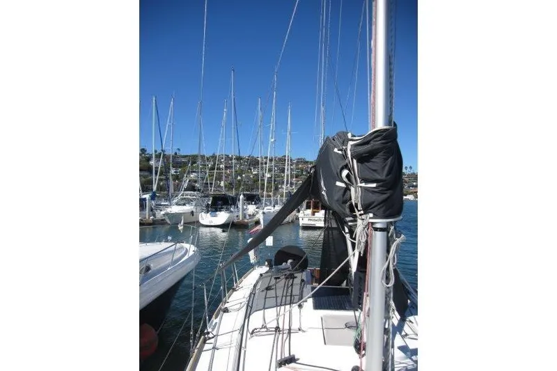Slide: The Image of 2021 Jeanneau Sun Odyssey 349 sailboat docked in a marina under clear blue skies. - 50