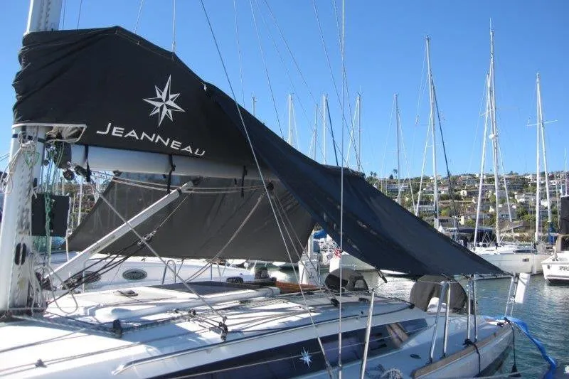 Slide: The Image of 2021 Jeanneau Sun Odyssey 349 sailboat docked in marina, featuring black sail cover. - 52