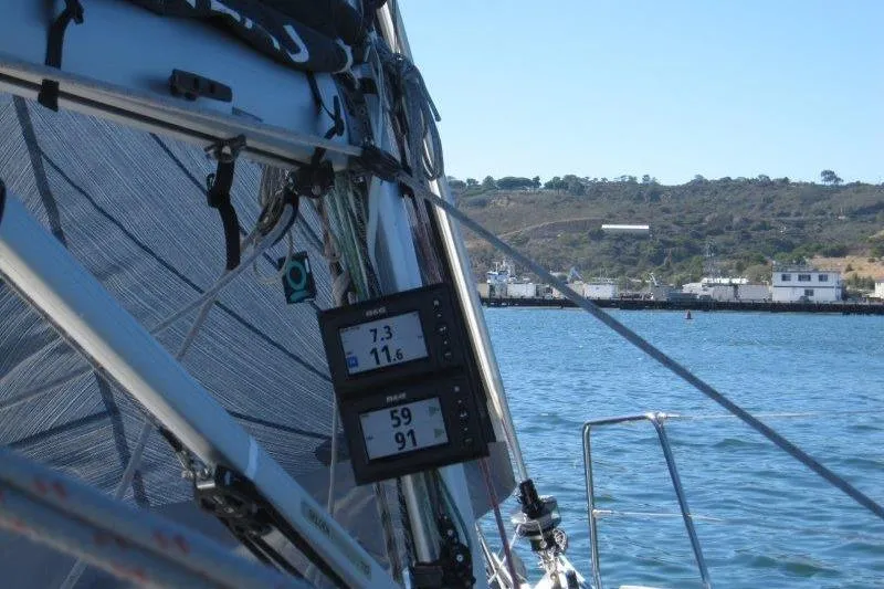 Slide: The Image of Jeanneau Sun Odyssey 349 sailboat with navigation instruments, sailing near a coastal area. - 62
