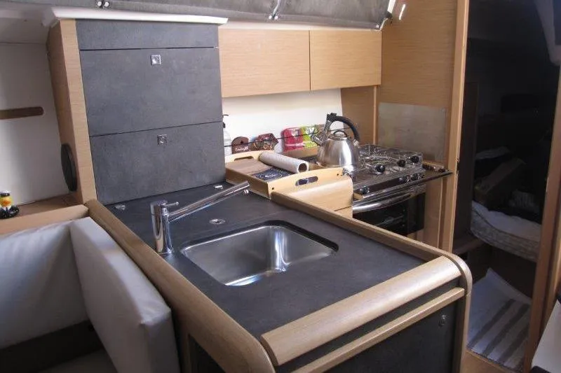 Slide: The Image of Modern kitchen interior of 2021 Jeanneau Sun Odyssey 349 sailboat, featuring sink and stove. - 8