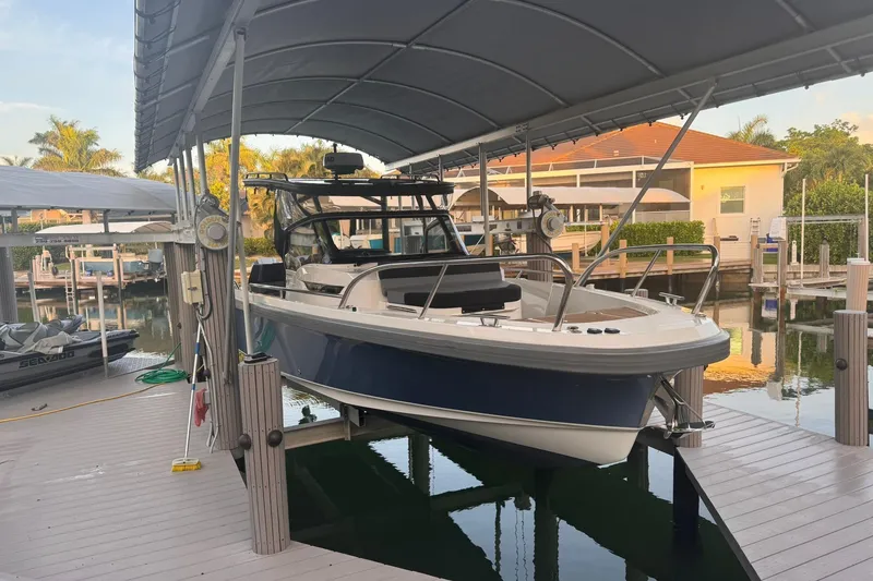 Slide: The Image of 2021 Nimbus T9 boat docked under a canopy in a marina setting. - 4