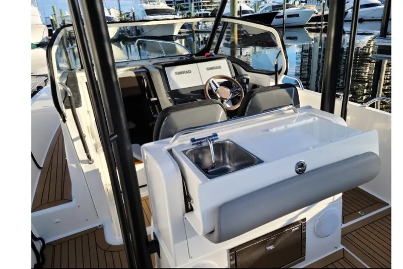 Slide: The Image of 2021 Nimbus T9 boat interior with steering wheel, sink, and modern dashboard at marina. - 6