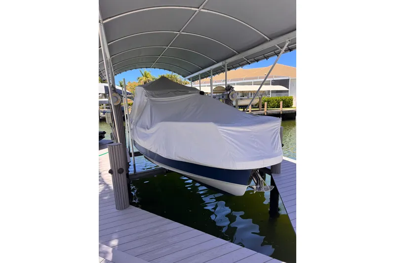 Slide: The Image of Covered 2021 Nimbus T9 boat docked under a canopy. - 16