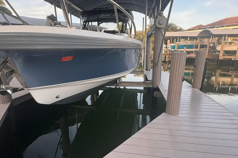 Slide: The Image of 2021 Nimbus T9 boat docked on a lift at a marina. - 20