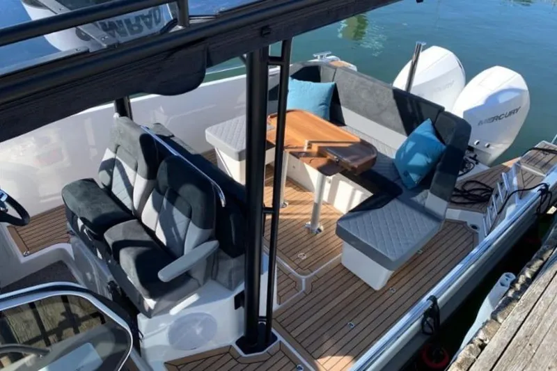 Slide: The Image of 2021 Nimbus T9 boat interior with seating, table, and Mercury engines. - 8