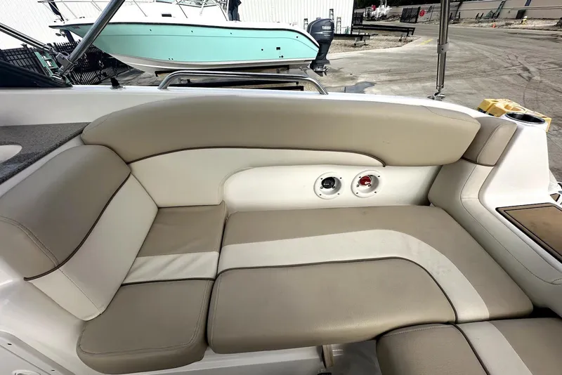 Slide: The Image of 2022 NauticStar 243 DC boat interior with beige seating and cup holders. - 11