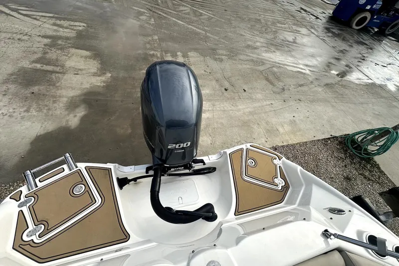 Slide: The Image of 2022 NauticStar 243 DC boat with Yamaha 200 engine, docked on wet concrete surface. - 18