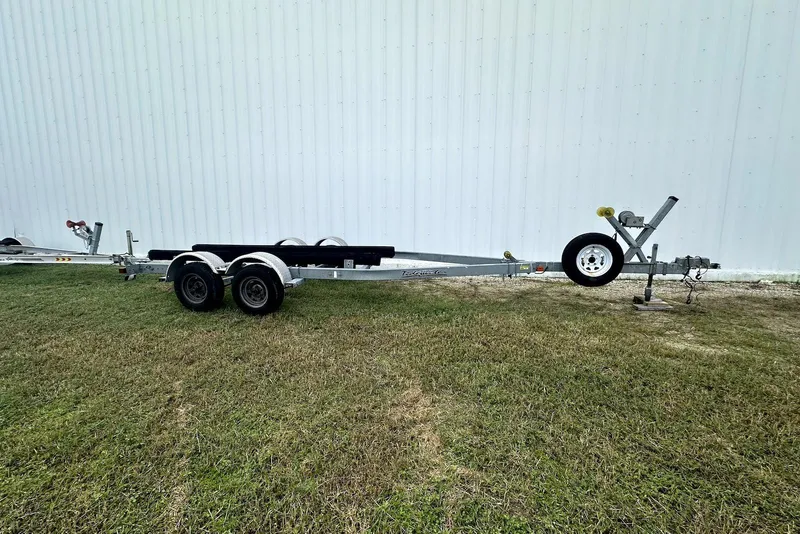 Slide: The Image of Trailer for 2022 NauticStar 243 DC boat on grass, near white wall. - 19