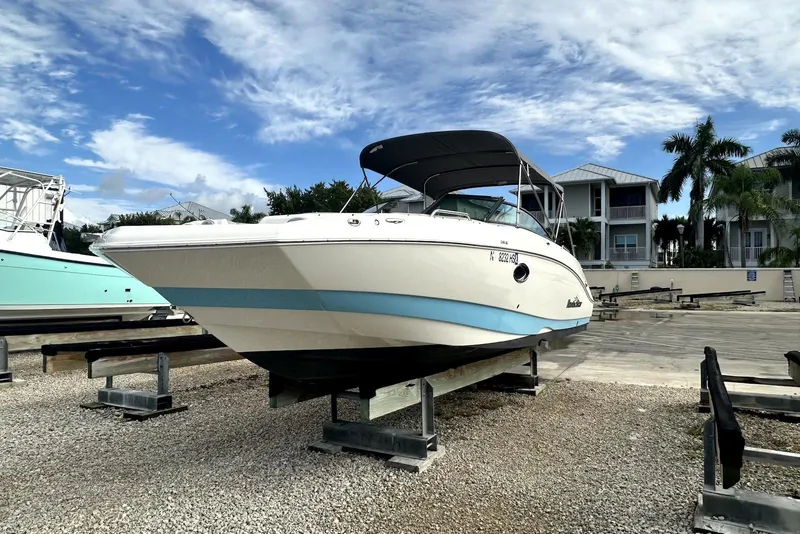 Slide: The Image of 2022 NauticStar 243 DC boat on dry dock under a clear blue sky. - 2