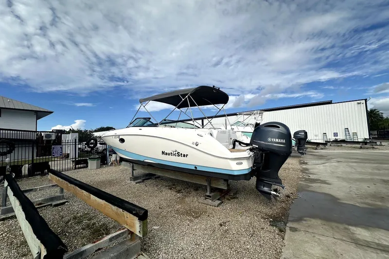 Slide: The Image of 2022 NauticStar 243 DC boat with Yamaha engine on display outdoors. - 6