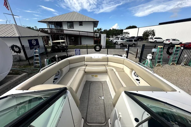 Slide: The Image of 2022 NauticStar 243 DC boat with spacious seating, docked near a marina. - 8