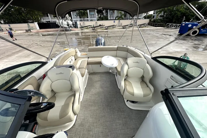 Slide: The Image of 2022 NauticStar 243 DC boat interior with beige seating and canopy. - 9