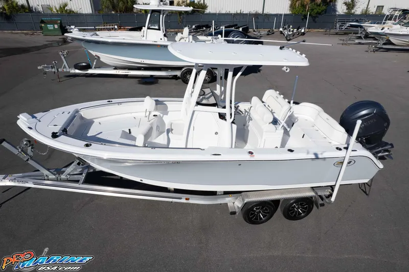 Slide: The Image of 2025 Sea Hunt Ultra 229 boat on trailer, displayed outdoors at a dealership. - 13