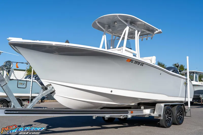 Slide: The Image of 2025 Sea Hunt Ultra 229 boat on trailer, displayed outdoors under clear blue sky. - 16