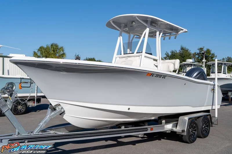 Slide: The Image of 2025 Sea Hunt Ultra 229 boat on trailer, displayed outdoors under clear blue sky. - 18