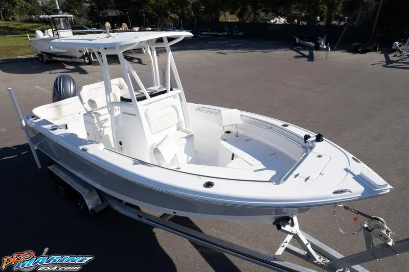 Slide: The Image of 2025 Sea Hunt Ultra 229 boat on trailer, displayed outdoors in a parking area. - 2