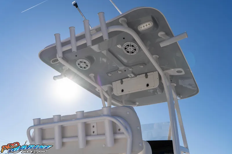 Slide: The Image of 2025 Sea Hunt Ultra 229 boat T-top with rod holders and speakers under clear sky. - 30