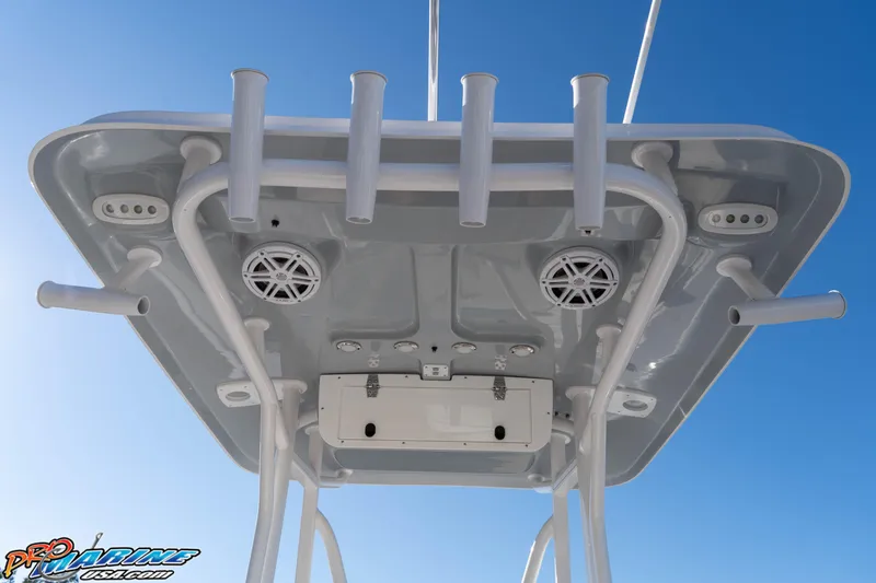 Slide: The Image of 2025 Sea Hunt Ultra 229 boat T-top with rod holders and speakers against blue sky. - 37