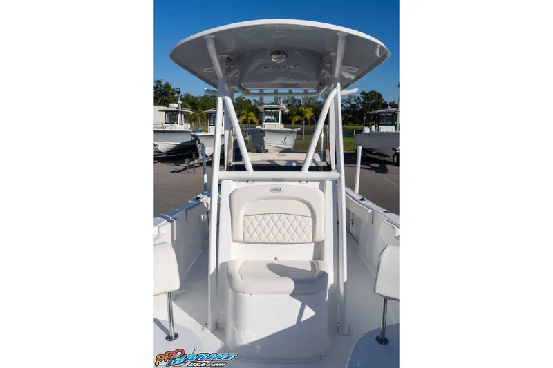 Slide: The Image of 2025 Sea Hunt Ultra 229 boat with T-top and seating, docked under clear blue sky. - 40