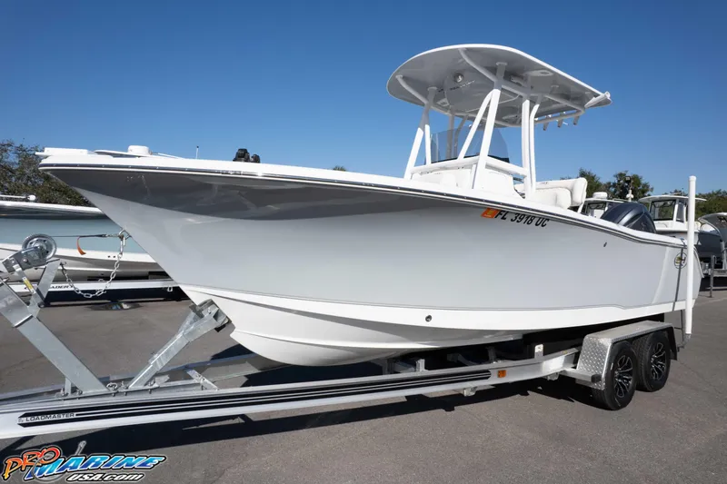 Slide: The Image of 2025 Sea Hunt Ultra 229 boat on trailer under clear blue sky. - 7