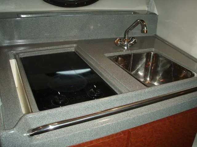 Slide: The Image of 2003 Wellcraft 3300 Martinique galley with sink and stovetop, featuring sleek countertops. - 15