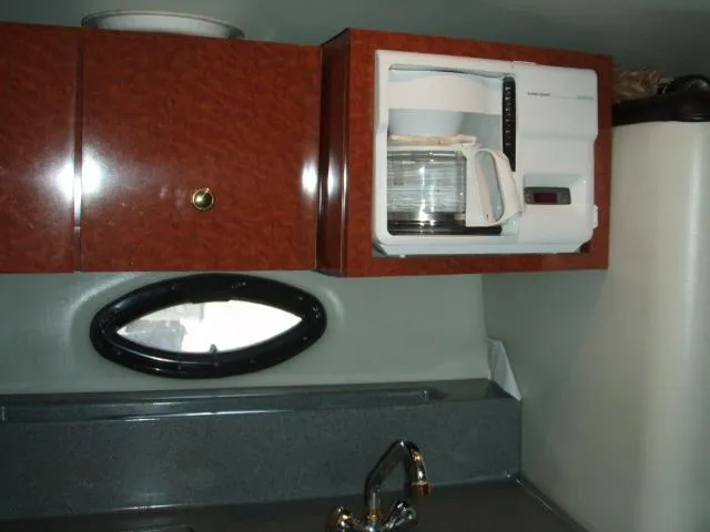 Slide: The Image of 2003 Wellcraft 3300 Martinique kitchen with microwave, cabinets, and sink. - 17
