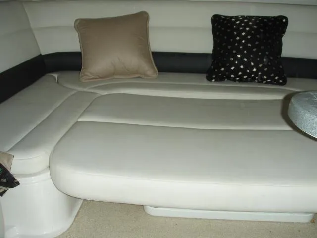 Slide: The Image of 2003 Wellcraft 3300 Martinique interior with beige seating and decorative pillows. - 21