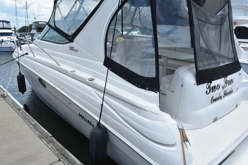 Slide: The Image of 2003 Wellcraft 3300 Martinique boat docked at marina, featuring sleek white design. - 4