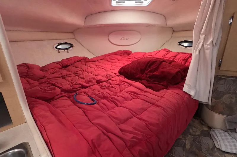Slide: The Image of Cozy cabin interior of 2000 Bayliner 2855 Ciera with red bedding and portholes. - 6