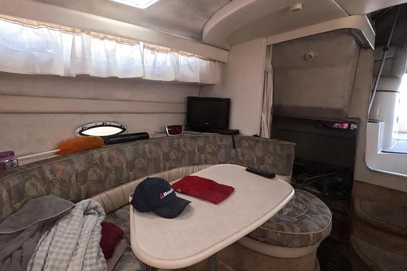Slide: The Image of Interior of 2000 Bayliner 2855 Ciera boat with cozy seating and table setup. - 8