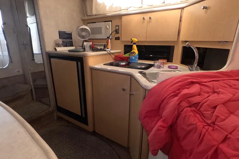 Slide: The Image of Interior of 2000 Bayliner 2855 Ciera boat with kitchenette and cozy bedding. - 9