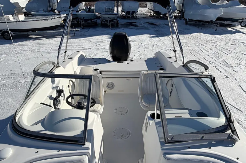 Slide: The Image of 2006 Boston Whaler 180 Ventura boat interior with seating and steering wheel, parked on snow. - 7