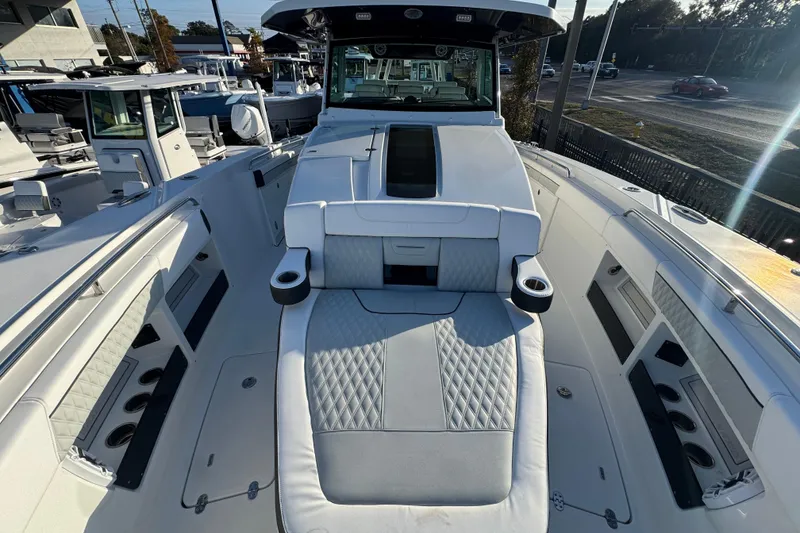 Slide: The Image of 2026 Blackfin 400 CC boat with spacious deck and seating, parked near a road. - 12