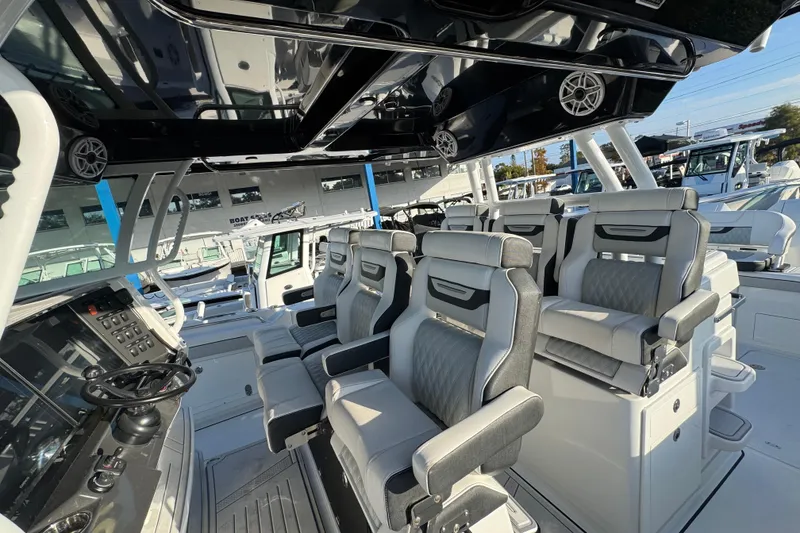 Slide: The Image of 2026 Blackfin 400 CC boat displayed at a dealership, showcasing spacious deck and seating. - 16