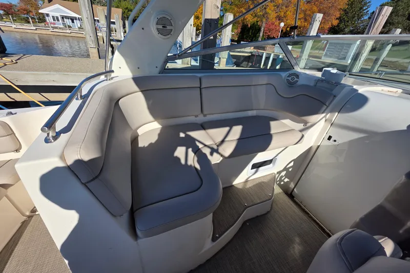 Slide: The Image of 2005 Rinker 300 Express Cruiser interior seating with beige upholstery and waterfront view. - 13