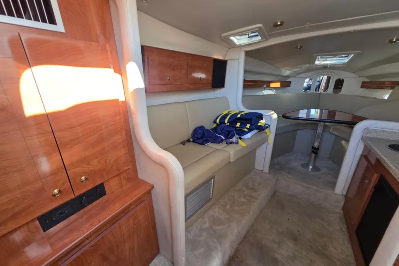 Slide: The Image of Interior of 2005 Rinker 300 Express Cruiser with seating, table, and wood cabinetry. - 17
