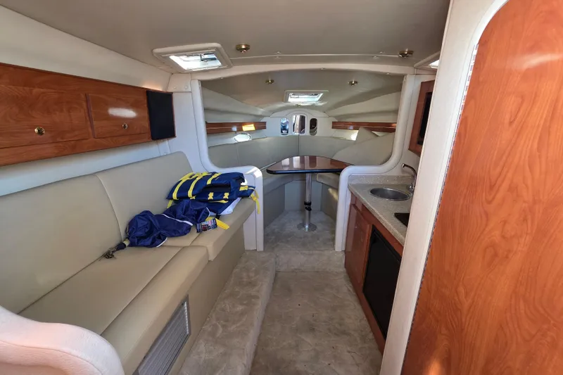 Slide: The Image of 2005 Rinker 300 Express Cruiser interior with seating, table, and kitchenette. - 18